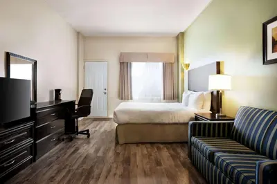 a hotel room with a bed and a couch at Days Inn by Wyndham Ste. Helene-de-Bagot in Sainte-Hélène-de-Bagot