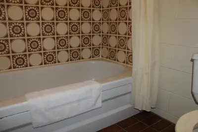 a bathroom with a bath tub with a towel on it at Auberge - Motel Le Pigeonnier in Farnham
