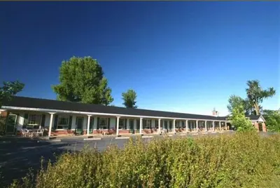 a large building with tables and chairs in front of it at Auberge - Motel Le Pigeonnier in Farnham