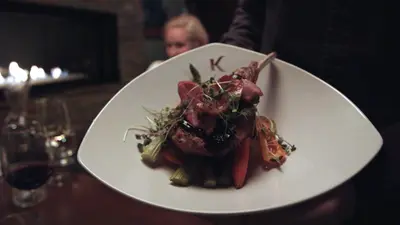 a plate of food with meat and vegetables on a table at Kinipi Spa Nordique & Hebergement in Trois-Rivières