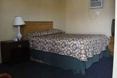a bedroom with a bed and a lamp on a night stand at Motel Montreal in Notre-Dame-de-l'Île-Perrot