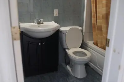 a bathroom with a white toilet and a sink at Motel Montreal in Notre-Dame-de-l'Île-Perrot