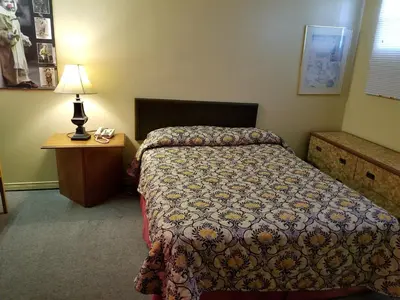 a bedroom with a bed and a lamp and a table at Motel Montreal in Notre-Dame-de-l'Île-Perrot