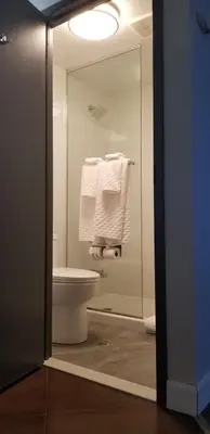 a bathroom with a toilet and a shower with towels at Best Western Laval-Montreal & Conference Centre in Laval