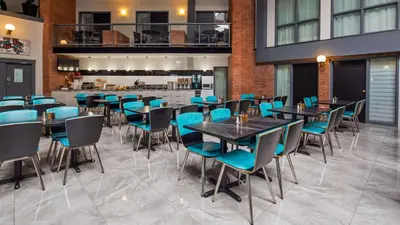 a dining room with tables and blue chairs at Best Western Laval-Montreal & Conference Centre in Laval