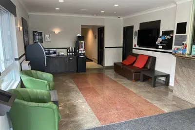 a living room with green chairs and a couch at Ramada by Wyndham Laval in Laval