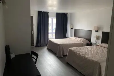 a hotel room with two beds and a window at Ramada by Wyndham Laval in Laval