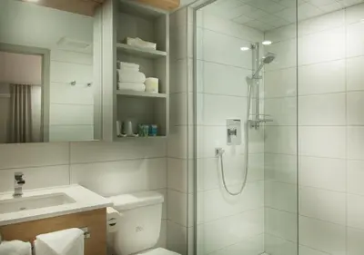 a bathroom with a shower and a toilet and a sink at Ramada by Wyndham Laval in Laval