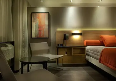 a bedroom with a bed and a table and a chair at Ramada by Wyndham Laval in Laval