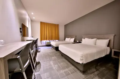 a hotel room with two beds and a window at Hôtel Ô Laval in Laval