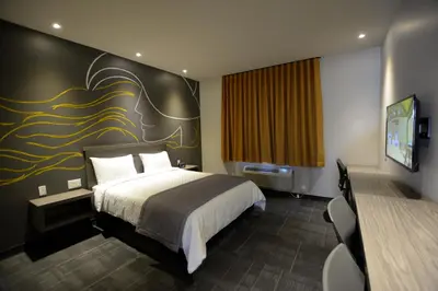 a hotel room with a bed and a flat screen tv at Hôtel Ô Laval in Laval