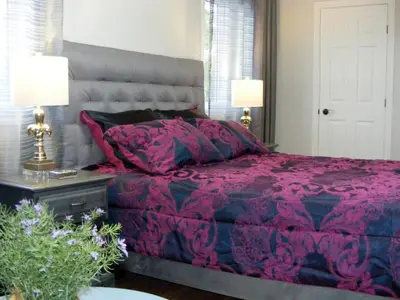 a bedroom with a pink bed and two lamps at Gite L'Antre d'Eux in Sherbrooke