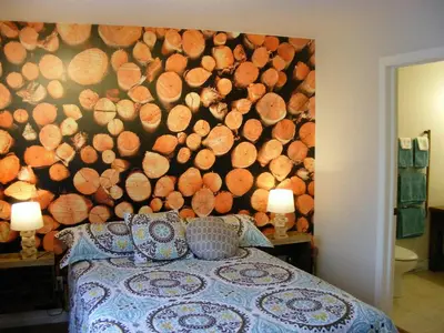 a bedroom with a large wall of logs at Gite L'Antre d'Eux in Sherbrooke