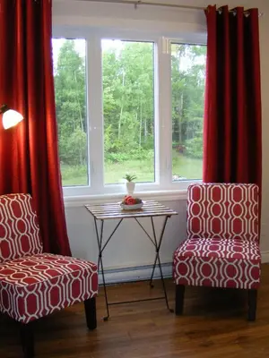 two chairs and a table in front of a window at Gite L'Antre d'Eux in Sherbrooke