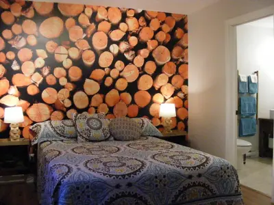a bedroom with a large wall of logs at Gite L'Antre d'Eux in Sherbrooke