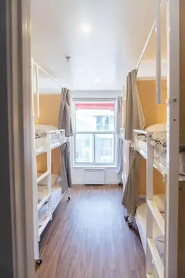 a room with four bunk beds and a window at Auberge Saintlo Montréal Hostel in Montréal