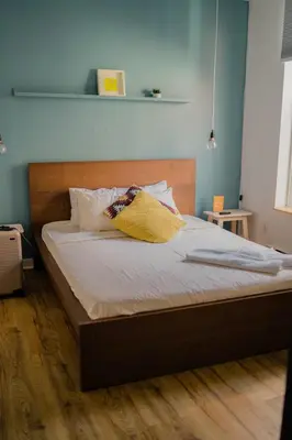 a bed with a wooden headboard in a bedroom at Auberge Saintlo Montréal Hostel in Montréal