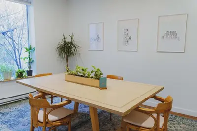 a table with chairs and a plant in a box at Auberge Saintlo Montréal Hostel in Montréal