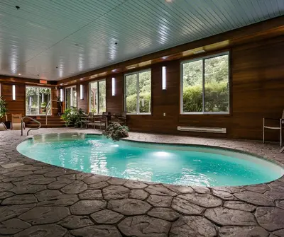 a large swimming pool in a building with windows at Hotel Montfort in Nicolet