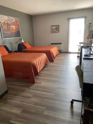 a hotel room with two beds and a window at Motel Populaire in Trois-Rivières