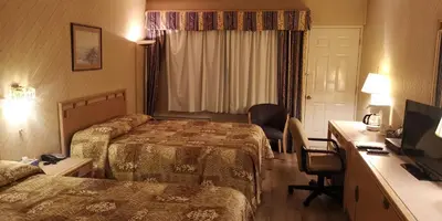 a hotel room with two beds and a desk at Hotel Motel Penn-Mass in Trois-Rivières