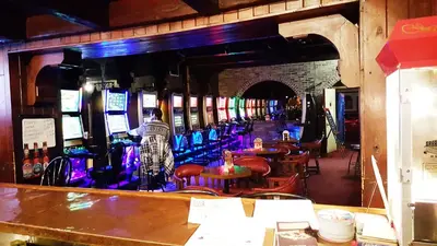 a bar with a man standing in front of a mirror at Hotel Motel Penn-Mass in Trois-Rivières