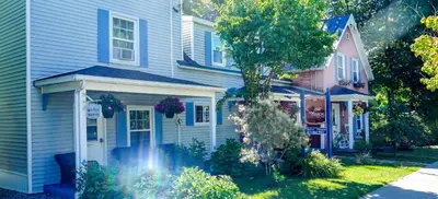 a blue house with a garden in front of it at Au Coeur De Magog in Magog-Orford