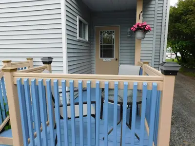 a porch with a blue fence and a table on a house at Au Coeur De Magog in Magog-Orford