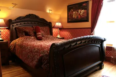 a bedroom with a bed with a red comforter at Ô Bois Dormant B&B in Magog-Orford