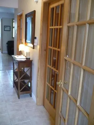 a hallway with a wooden door and a table at Gite Le Sieur de Joliette in Montréal