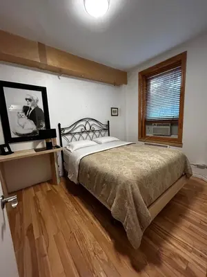 a bedroom with a large bed and a window at Gite Le Sieur de Joliette in Montréal