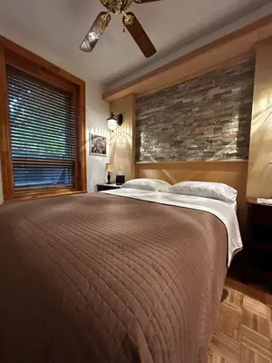a bedroom with a large bed with a brick wall at Gite Le Sieur de Joliette in Montréal