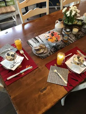 a wooden table with food and orange juice on it at Au Gré Du Temps - Gîte B&B in Shefford