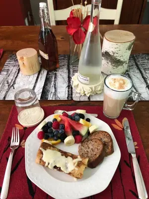 a plate of food with fruit and bread on a table at Au Gré Du Temps - Gîte B&B in Shefford