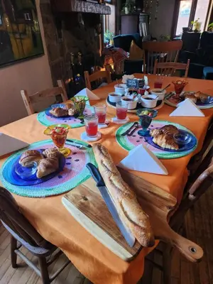 a long wooden table with plates of food on it at Guesthouse Refuge du Poète Montreal-Longueuil in Longueuil
