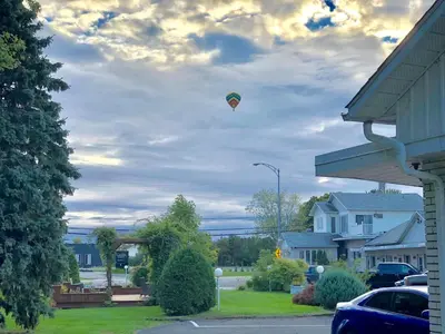a kite flying in the sky over a house at Motel Belle Riviere in Saint-Jean-sur-Richelieu