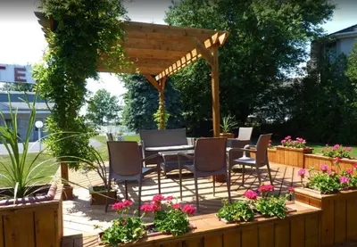 a patio with a table and chairs under a wooden pergola at Motel Belle Riviere in Saint-Jean-sur-Richelieu