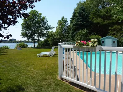 a white fence with flowers on it next to a pool at Motel Belle Riviere in Saint-Jean-sur-Richelieu