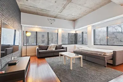 a living room with a bed and a couch at mtlFlats - Condotel Le Luxe in Montréal