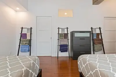 a room with two beds and a dresser in it at mtlFlats - Condotel Le Luxe in Montréal