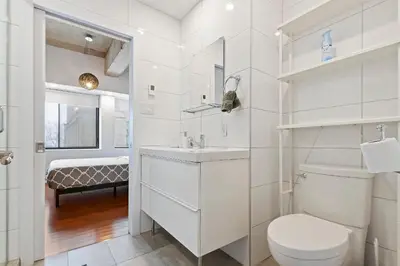 a white bathroom with a toilet and a sink at mtlFlats - Condotel Le Luxe in Montréal