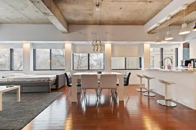 a kitchen and living room with a table and chairs at mtlFlats - Condotel Le Luxe in Montréal