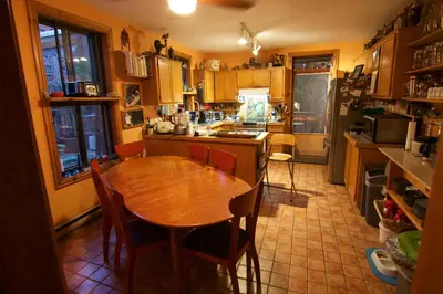 a kitchen with a wooden table and chairs in it at Gite L'Imprévu in Montréal