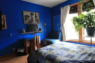 a bedroom with blue walls and a bed and a window at Gite L'Imprévu in Montréal