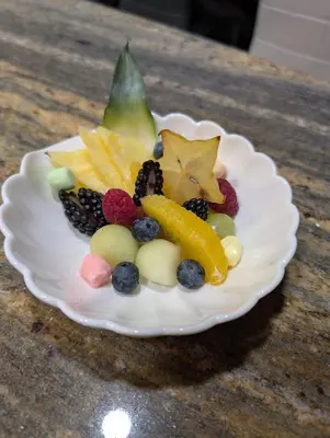 a white plate topped with fruit on a table at Au Saut Du Lit in Magog-Orford