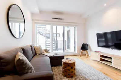 a living room with a couch and a tv at Hip, Stylish Apartment in Little Italy by Den Stays A in Montréal