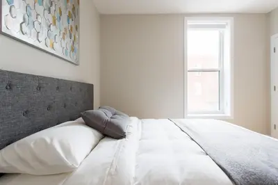 a bedroom with a large white bed with a window at Trendy Little Italy 3 Bedroom Condo Free parking in Montréal