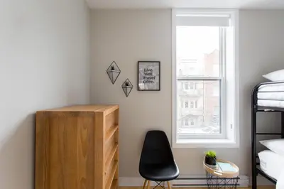 a bedroom with a desk and a chair next to a window at Trendy Little Italy 3 Bedroom Condo Free parking in Montréal