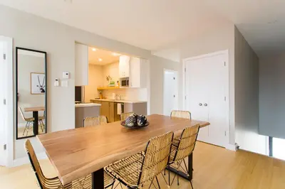 a dining room with a wooden table and chairs at Trendy Little Italy 3 Bedroom Condo Free parking in Montréal