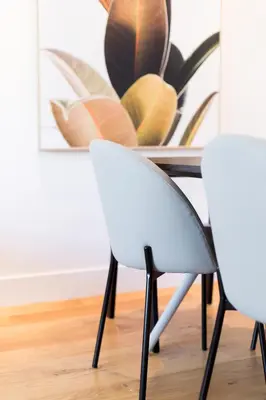 a dining room with two white chairs and a table at Little Italy Spacious 2 Bedroom Condo Free Parking in Montréal